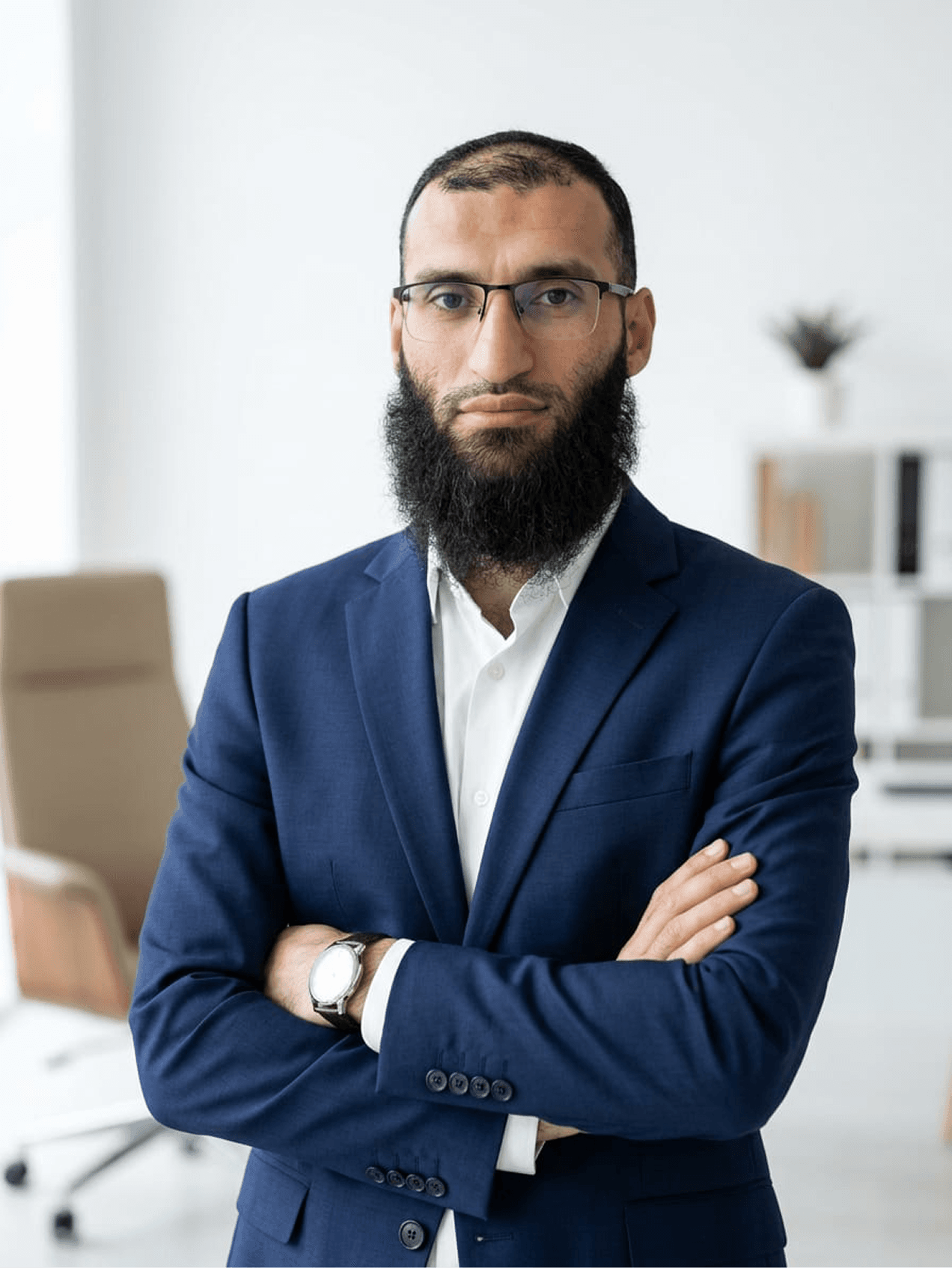 Sherzad standing in an office wearing a navy suit