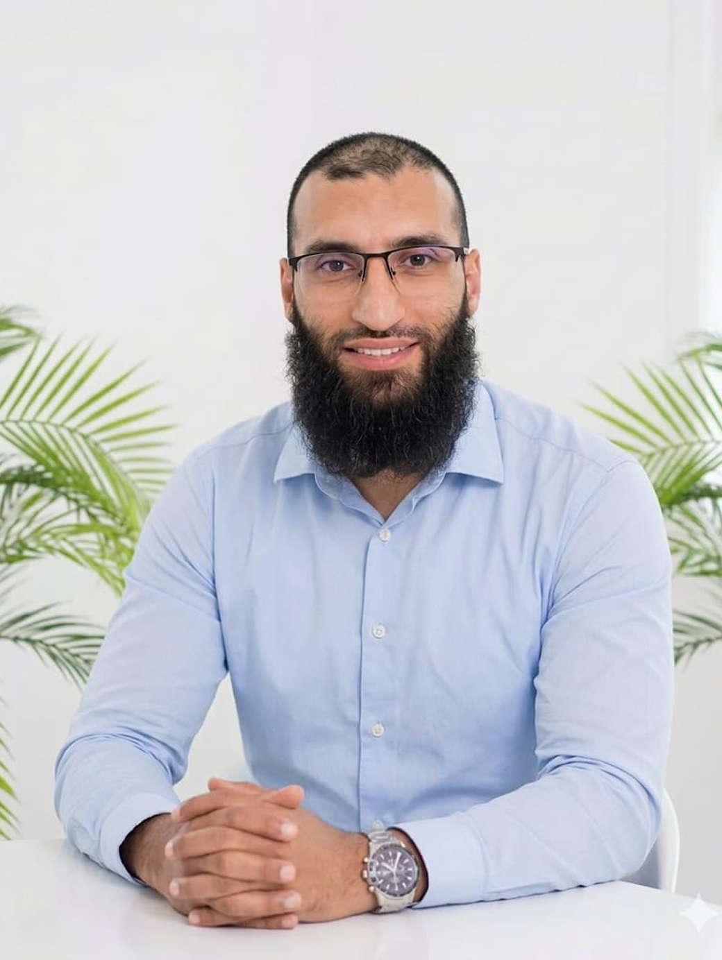Professional portrait at a desk with plants in the background