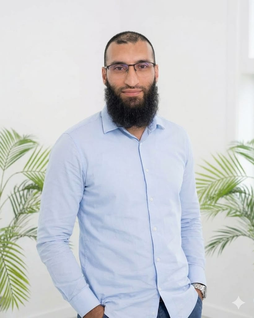 Professional portrait in a light blue shirt with plants in the background